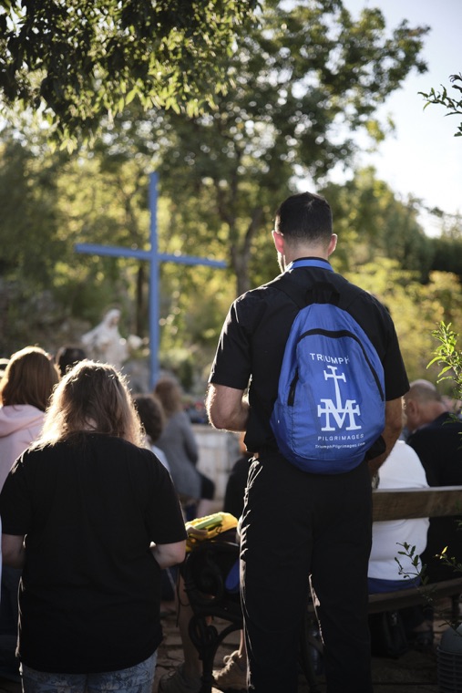 A pilgrim with a Triumph backpack at the blue cross