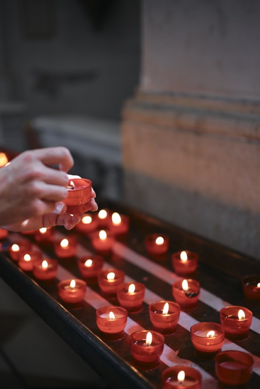 Votive candles being lit