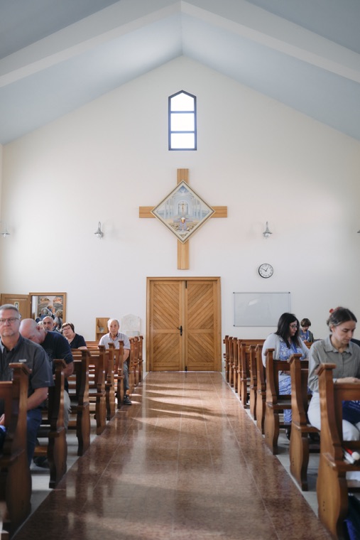 Pilgrims seated in a light-filled chapel