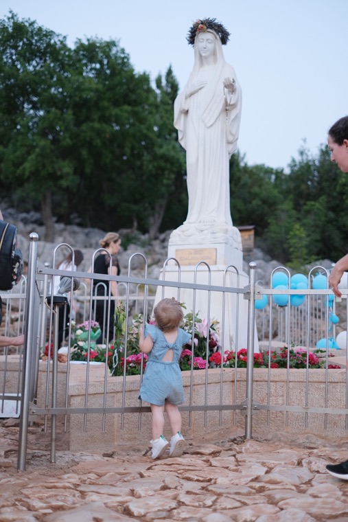 A small child before the statue of Our Lady