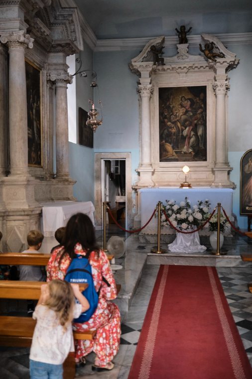 A mother and child before a side altar in a church