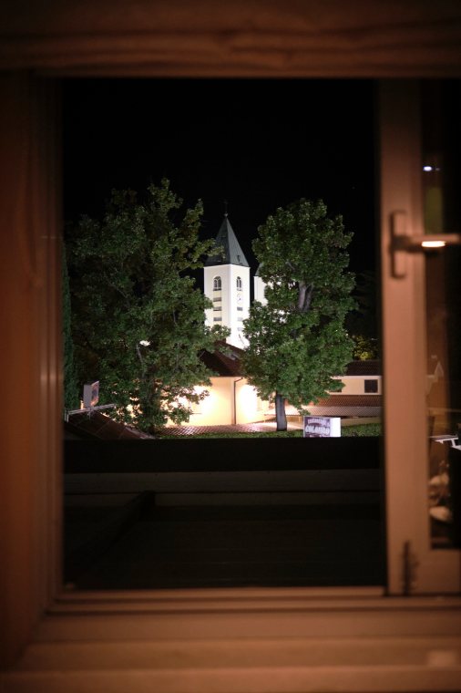 A church lit up at night, seen through a window