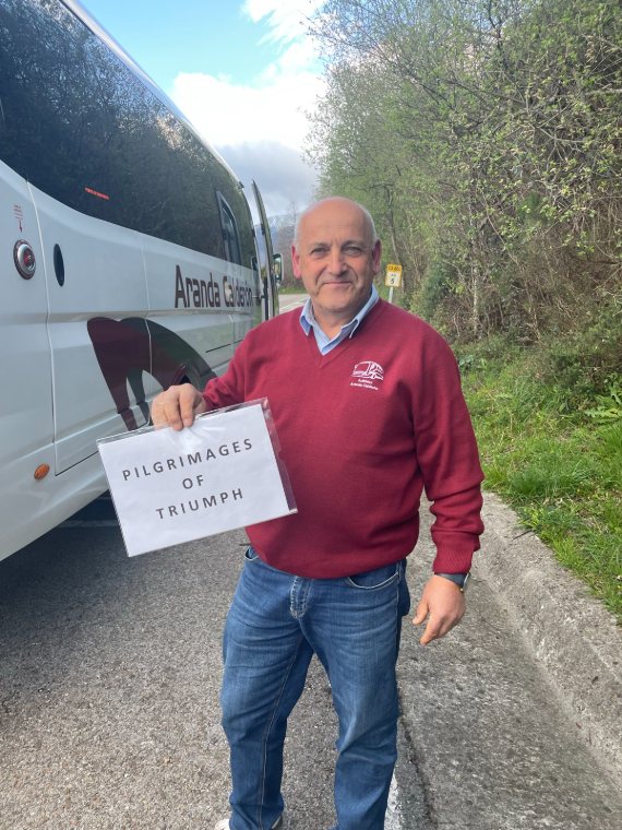 Our driver waiting by the coach with a Triumph sign