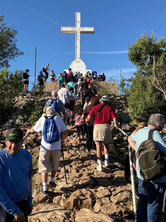 Pilgrims climbing the rocky path to the cross