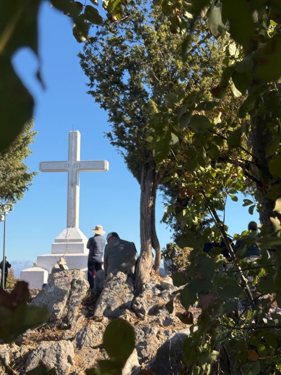 The cross through the branches, with pilgrims at its foot