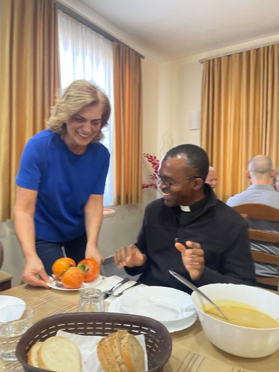 A pilgrim sharing fruit with a priest at dinner