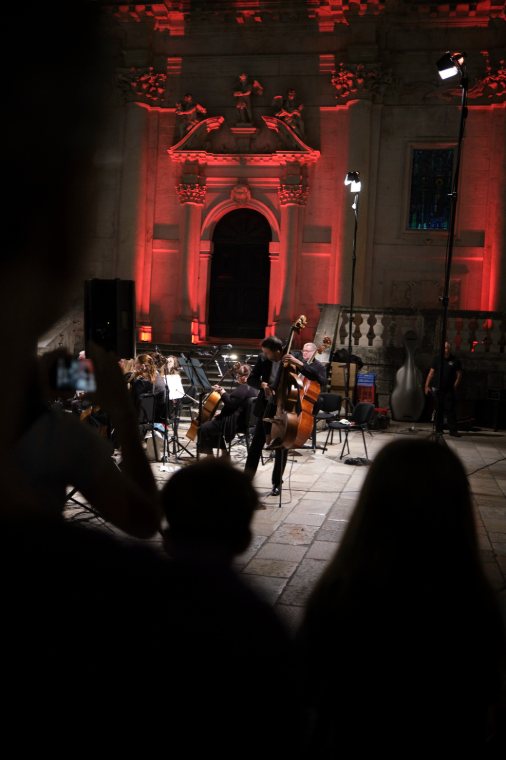 An evening concert before a church lit in red