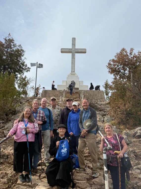 A group of pilgrims below the white cross on Cross Mountain