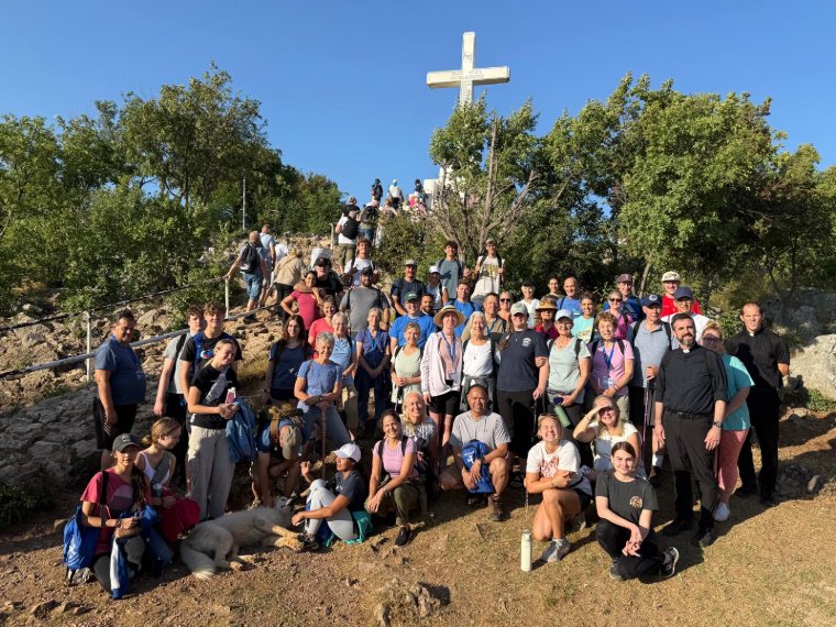 A large Triumph group on the path below the cross on Cross Mountain