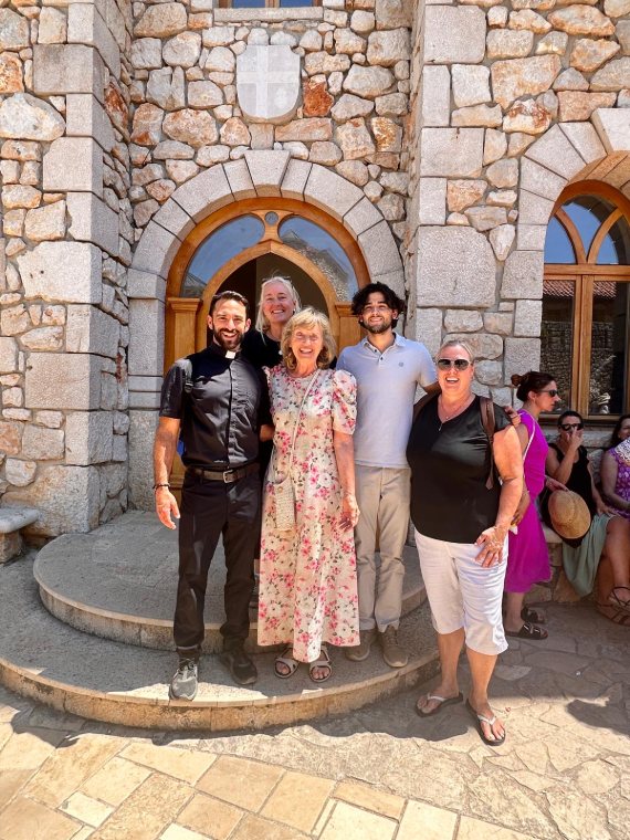 Pilgrims together outside a stone church doorway
