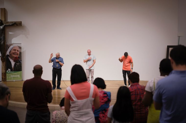Pilgrims listening to speakers in a hall