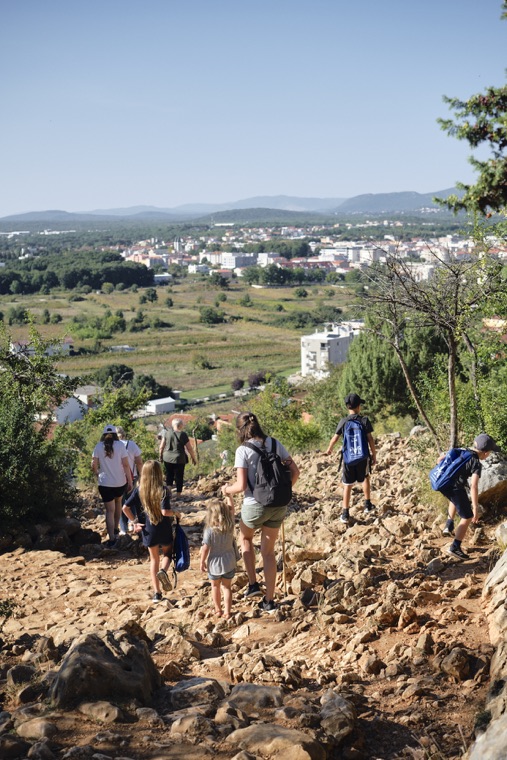 Pilgrims climbing the rocky path above the village