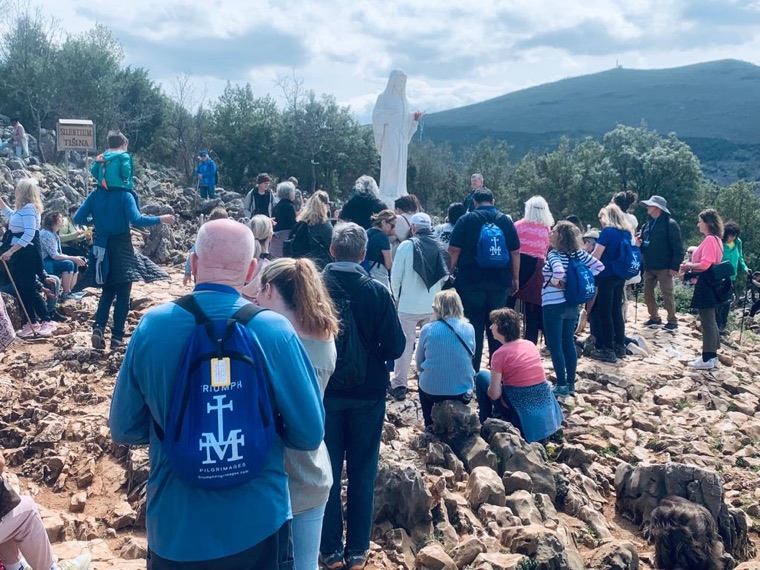 Pilgrims gathered before the statue on Apparition Hill