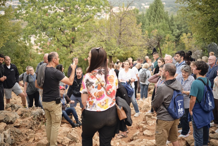Pilgrims praying together among the rocks on the hill