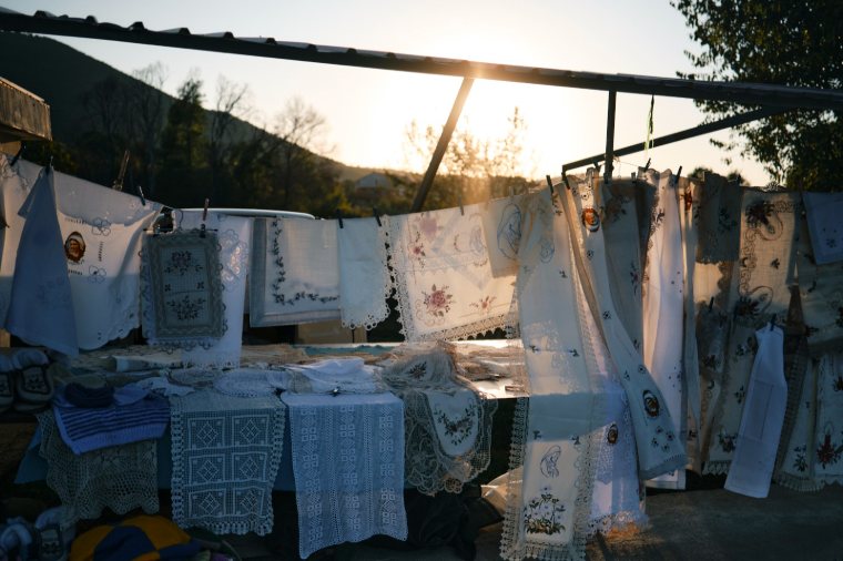 Embroidered lace hanging at a village stall at sunset