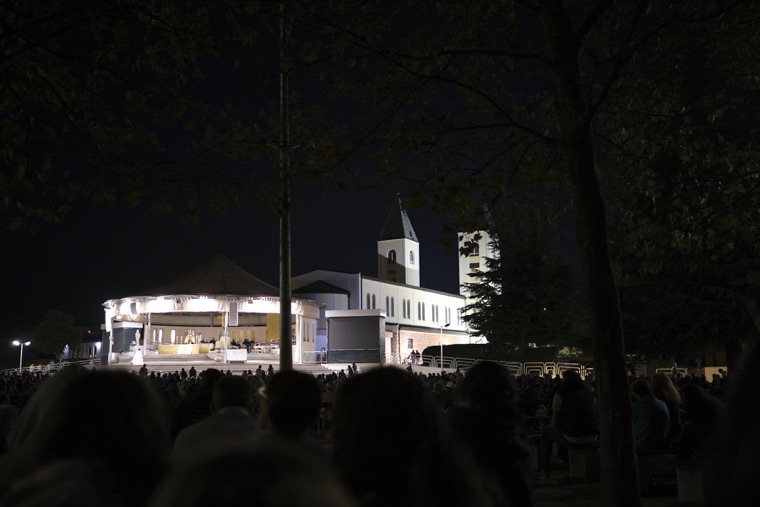 The outdoor altar lit up at night behind St James