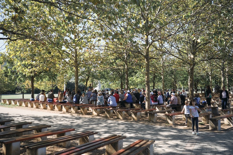 Rows of benches beneath the trees at the outdoor altar
