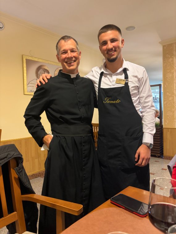 A priest and a waiter at dinner