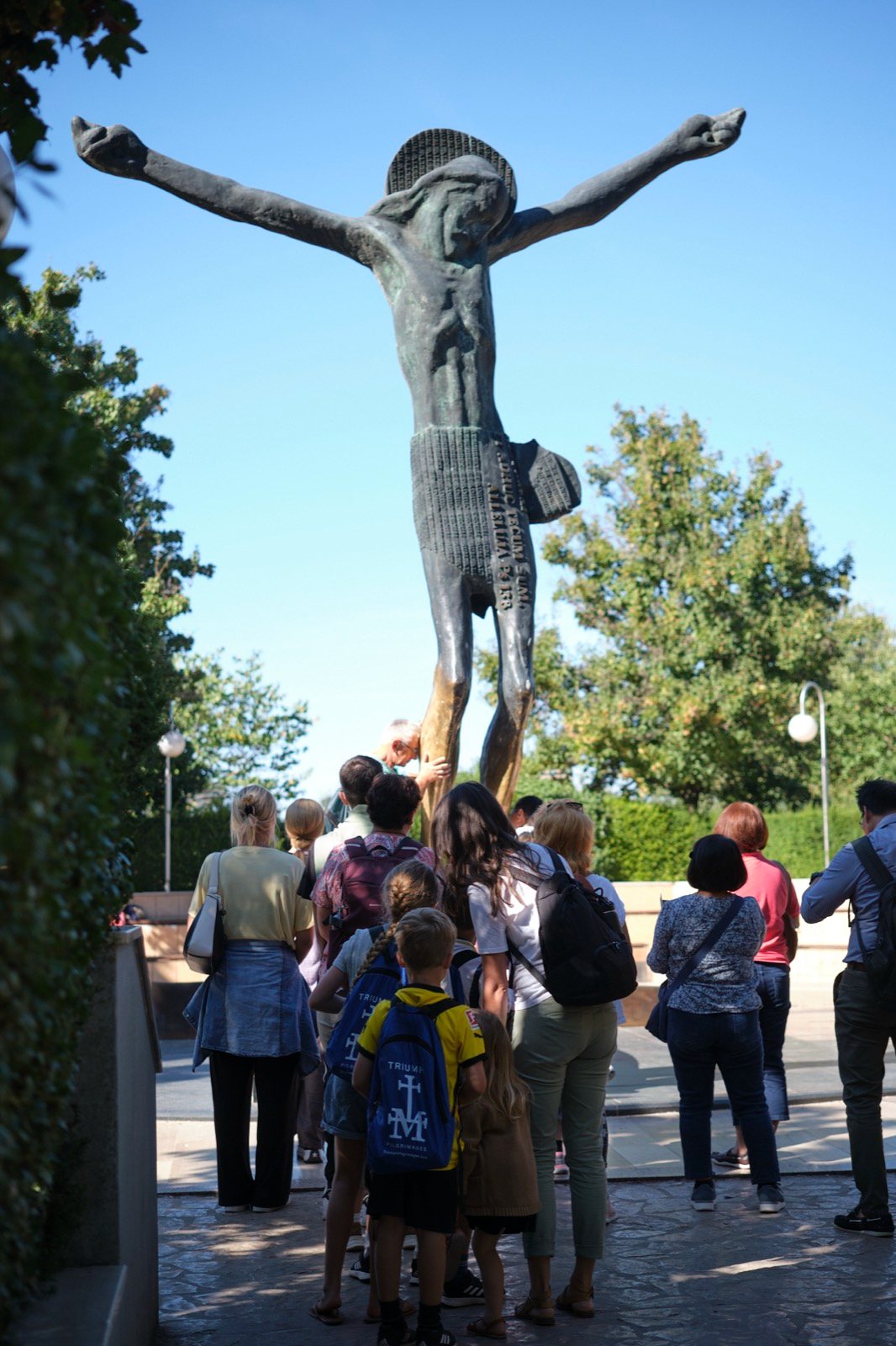 Pilgrims gathered at the bronze statue of the Risen Christ