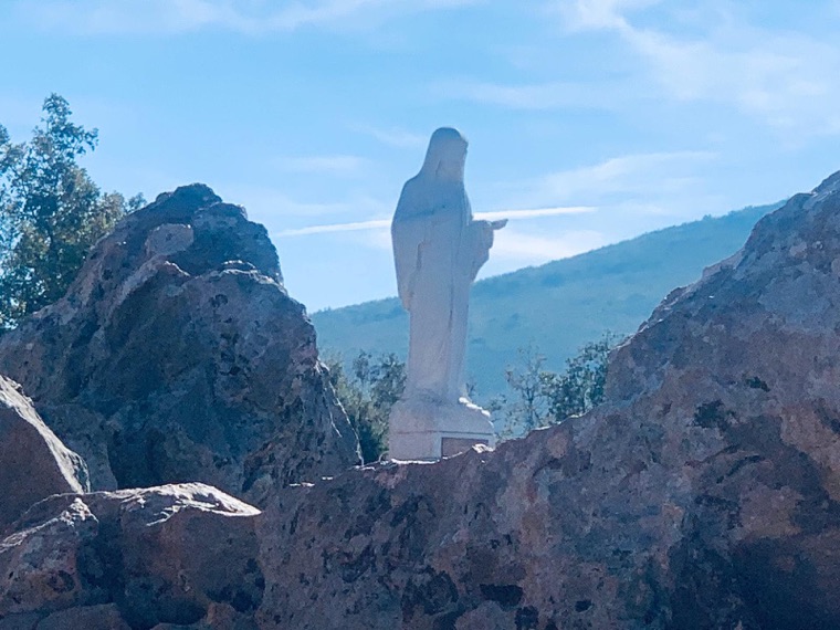 The statue of Our Lady among the rocks of the hillside