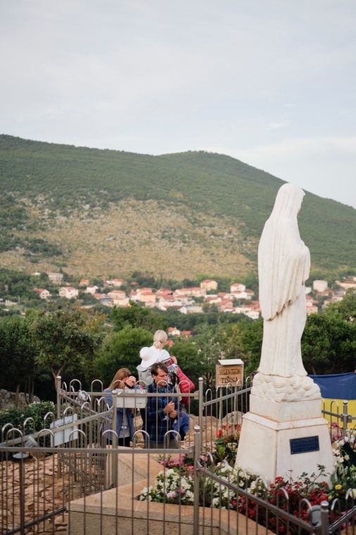 The statue of Our Lady, with the village and hills behind